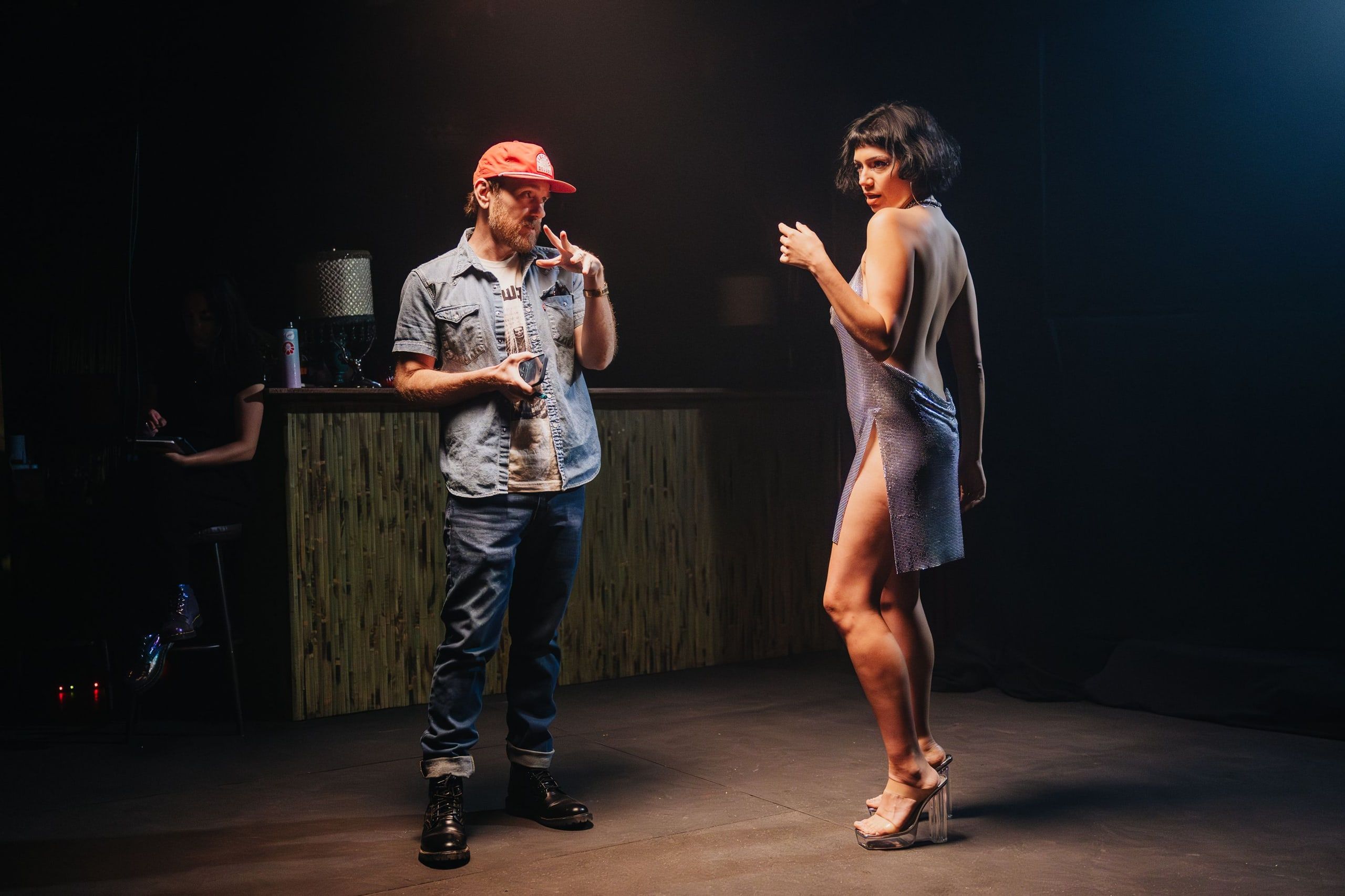 Walking a performer in a chainmail dress through her next move on a dim bar set