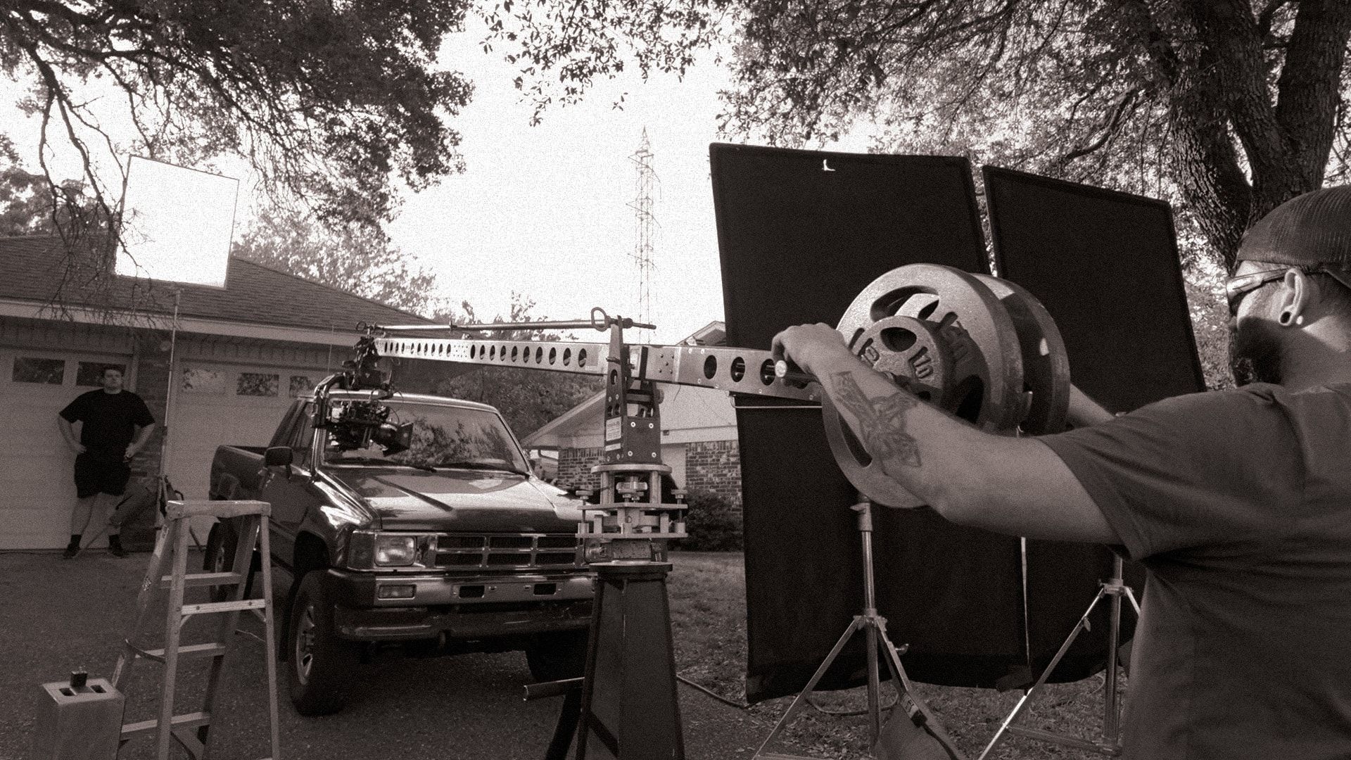 A jib arm set up in the driveway next to a pickup truck
