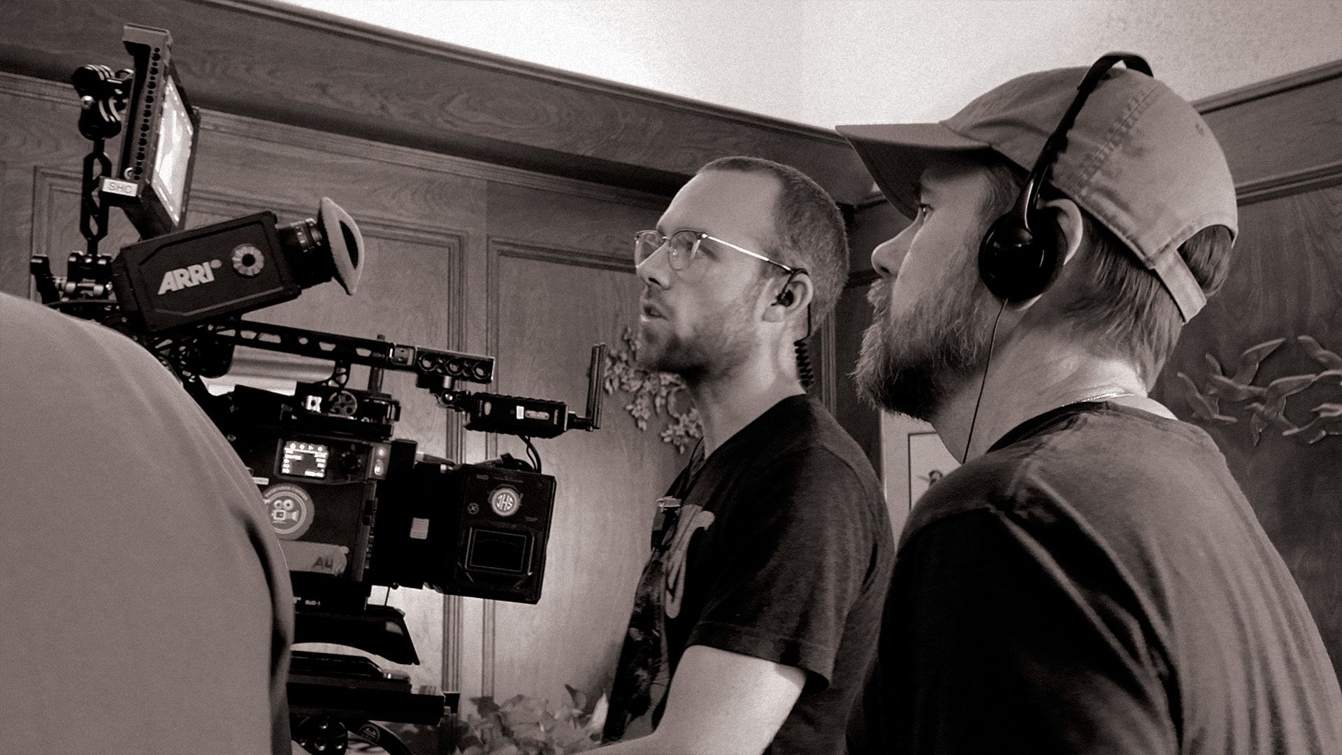 Two crew members at the camera, one in headphones