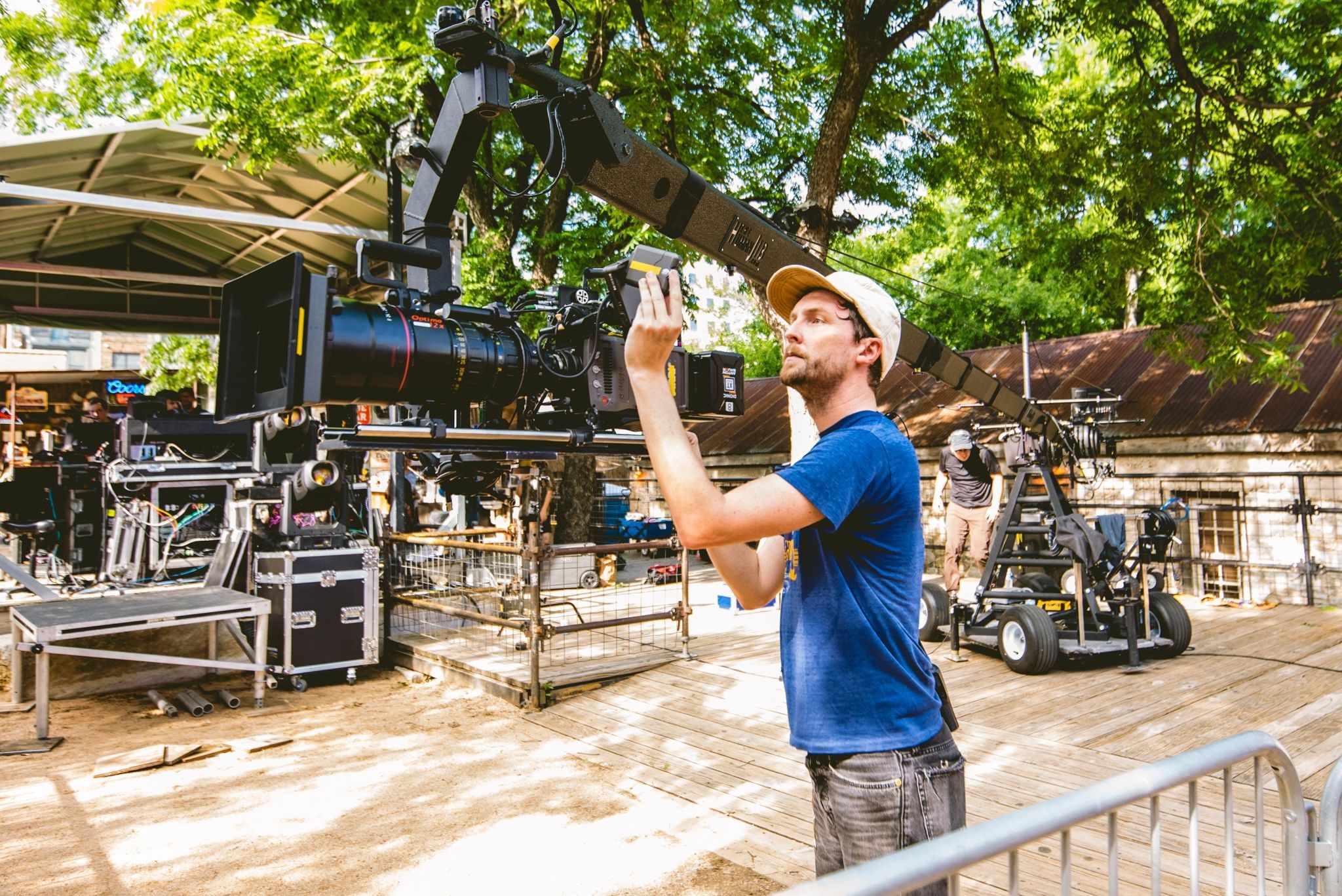 A camera assistant checks the camera on a jib arm at an outdoor music venue